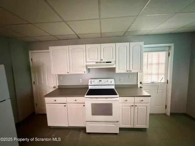 a kitchen with white cabinets and white appliances