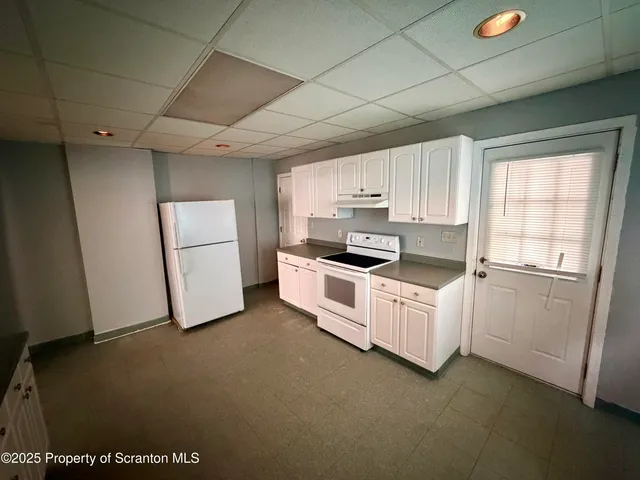 a kitchen with white cabinets and white appliances