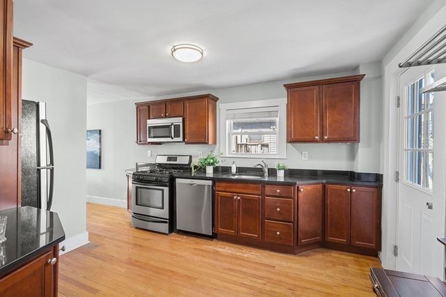 a kitchen with stainless steel appliances granite countertop a refrigerator and a stove top oven
