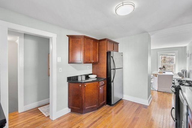 a kitchen with stainless steel appliances granite countertop a refrigerator a stove and a wooden floors