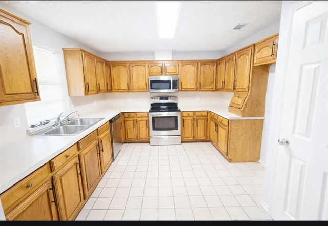 a kitchen with stainless steel appliances granite countertop a sink and a stove