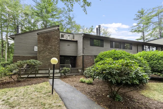 a front view of a house with a yard and garden