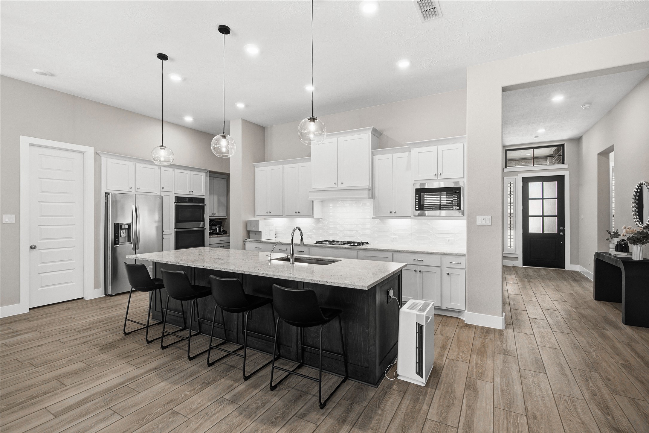 1222 McMurtry Ridge Drive Katy, TX 77494 - Photo 15 of 49 a kitchen with stainless steel appliances kitchen island granite countertop a sink a stove a refrigerator and white cabinets with wooden floor
