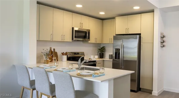 a kitchen with stainless steel appliances a refrigerator stove microwave and cabinets