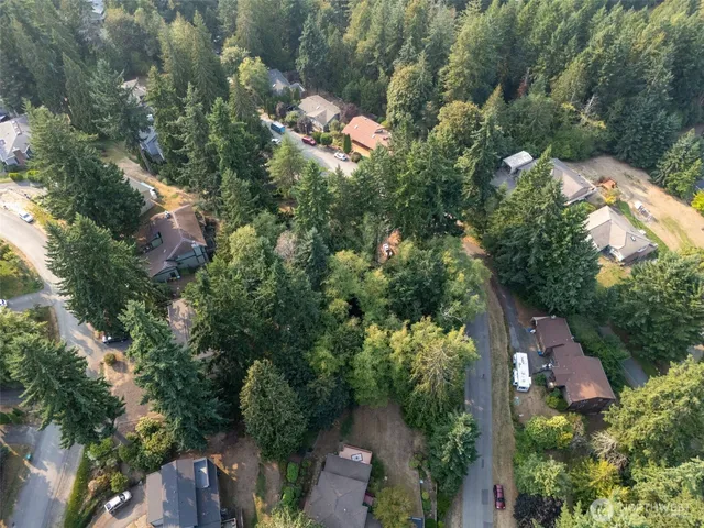 an aerial view of residential house with outdoor space and trees all around
