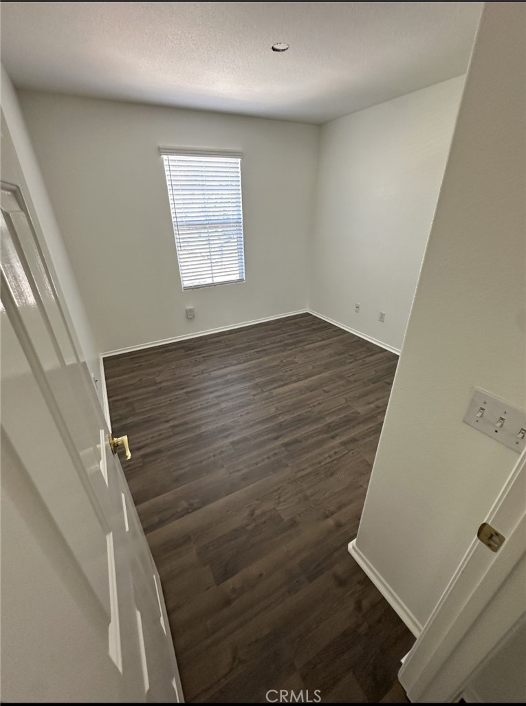 11306 Trailstone Court Riverside, CA 92505 - Photo 23 of 47 an empty room with wooden floor and windows