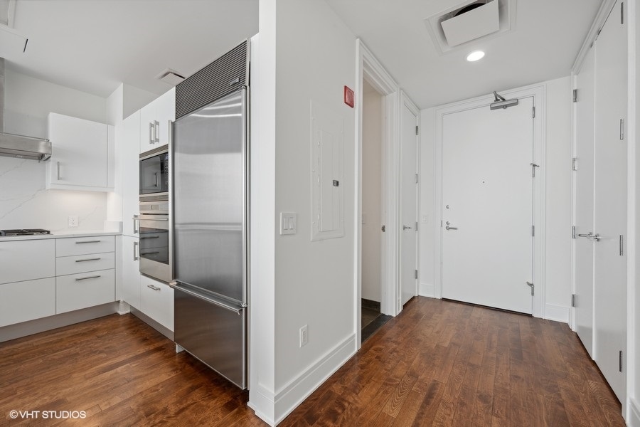 401 North Wabash Avenue, Unit 42E Chicago, IL 60611 - Photo 12 of 55 a kitchen with white cabinets and stainless steel appliances