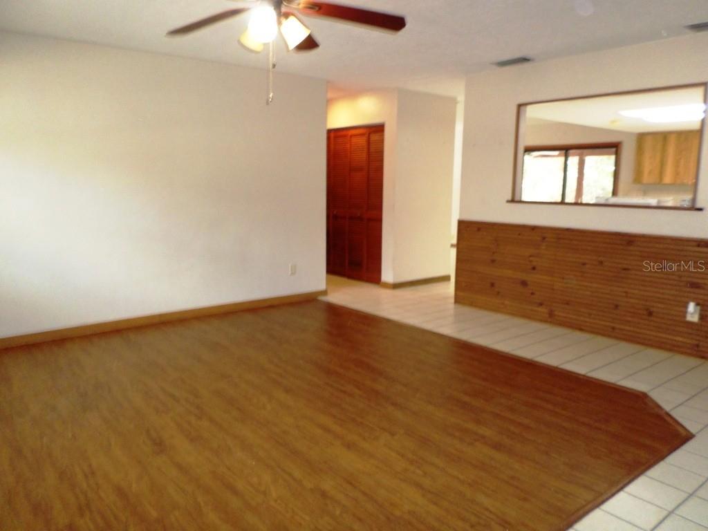 11606 Kennesaw Road Dunnellon, FL 34431 - Photo 6 of 33 an empty room with wooden floor and windows