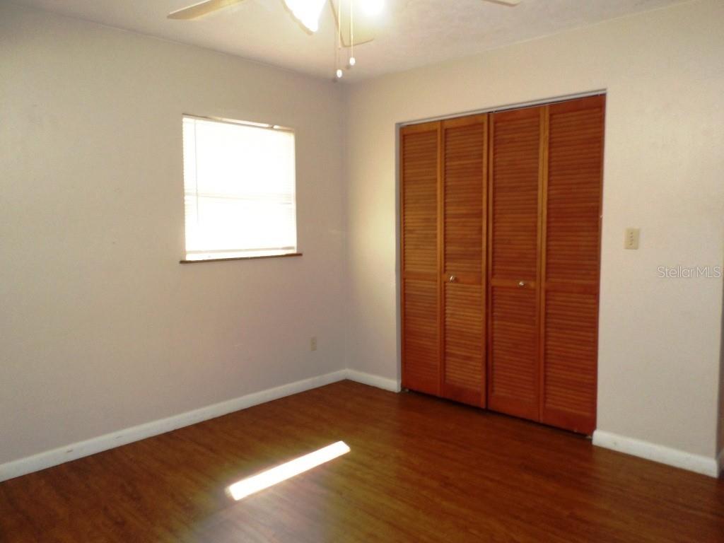 11606 Kennesaw Road Dunnellon, FL 34431 - Photo 8 of 33 an empty room with wooden floor closet and windows