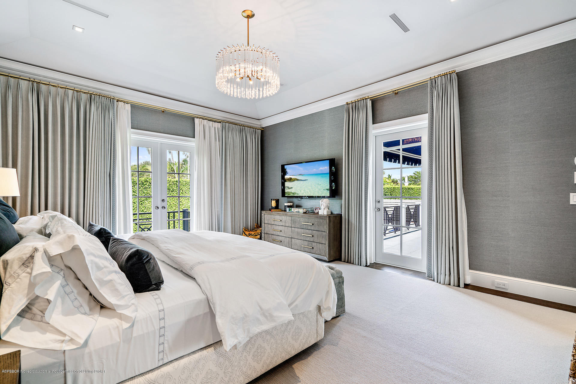 309 Dunbar Road Palm Beach, FL 33480 - Photo 16 of 24 a large bed sitting in a bedroom next to a window and a chandelier