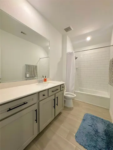 a bathroom with a double vanity sink toilet and shower