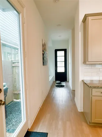 a view of a hallway with wooden floor and a living room
