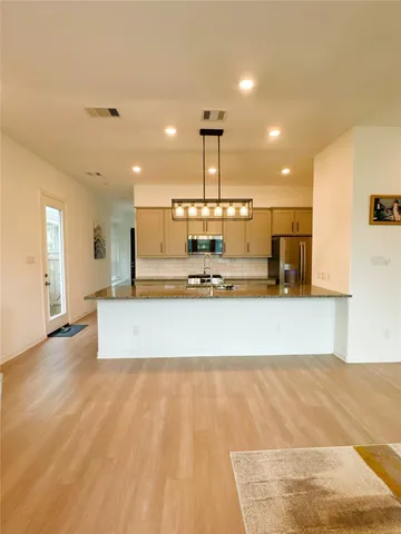 a view of a kitchen with kitchen island a counter top space a sink and appliances