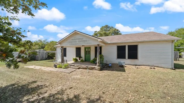 a front view of house with yard and trees in the background