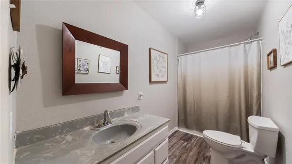 a bathroom with a granite countertop sink toilet and shower