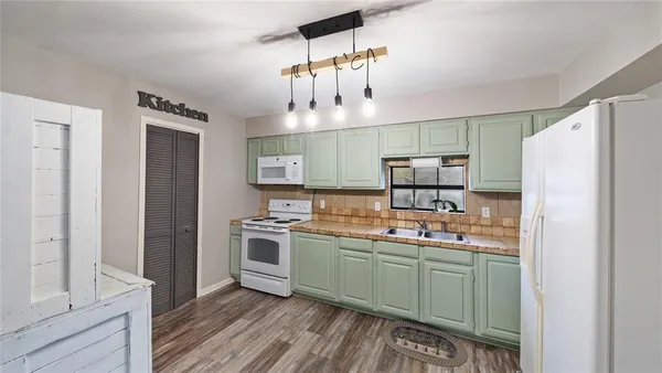 a kitchen with a sink a refrigerator and cabinets