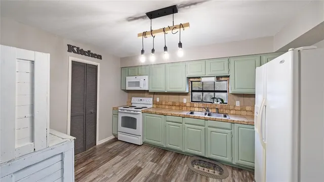a kitchen with a sink a refrigerator and cabinets