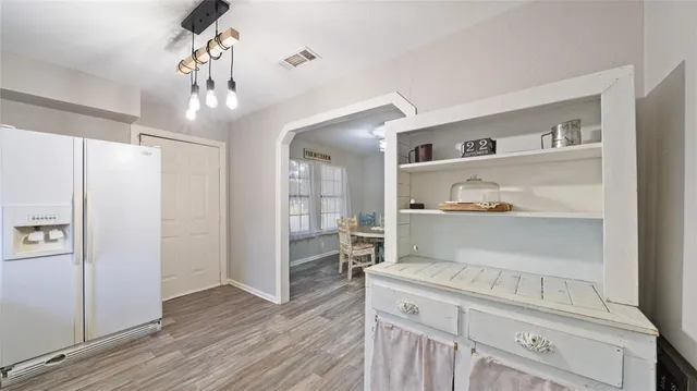 a kitchen with cabinets and wooden floor