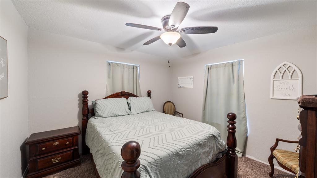 14260 North 3rd Street Scurry, TX 75158 - Photo 10 of 13 a bedroom with a bed and a chandelier