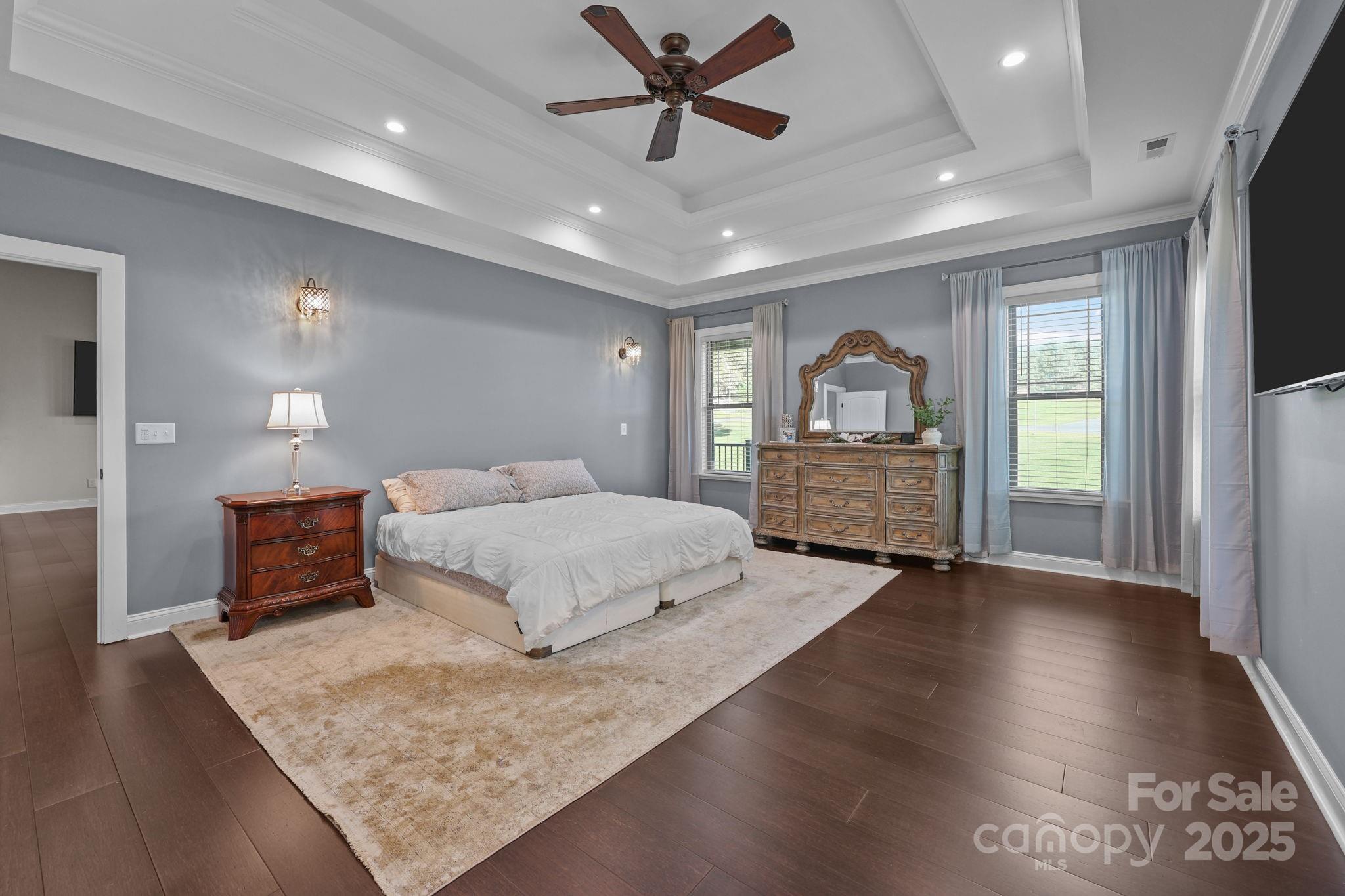 27040 Crepts Branch Road Locust, NC 28097 - Photo 23 of 48 a spacious bedroom with a bed and a dresser with wooden floor