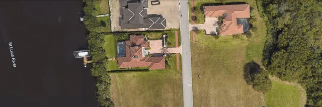 a living room with furniture a flat screen tv and a floor to ceiling window
