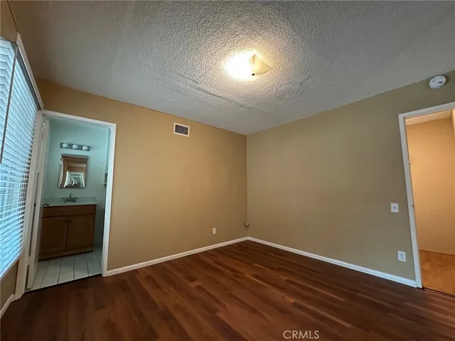 an empty room with wooden floor and closet