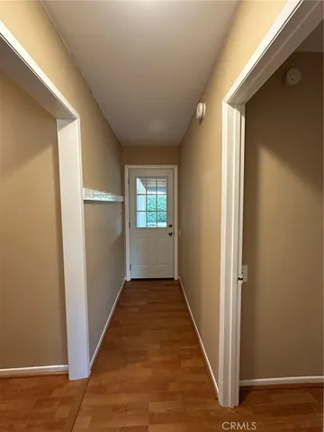 a view of a hallway with wooden floor and a living room