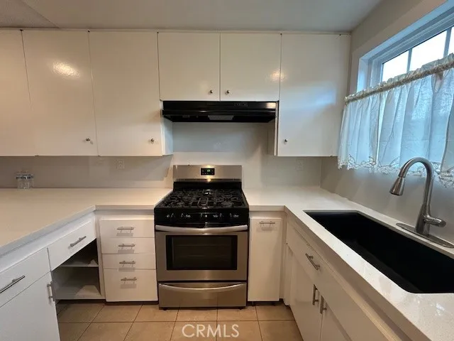 a kitchen with white cabinets and appliances