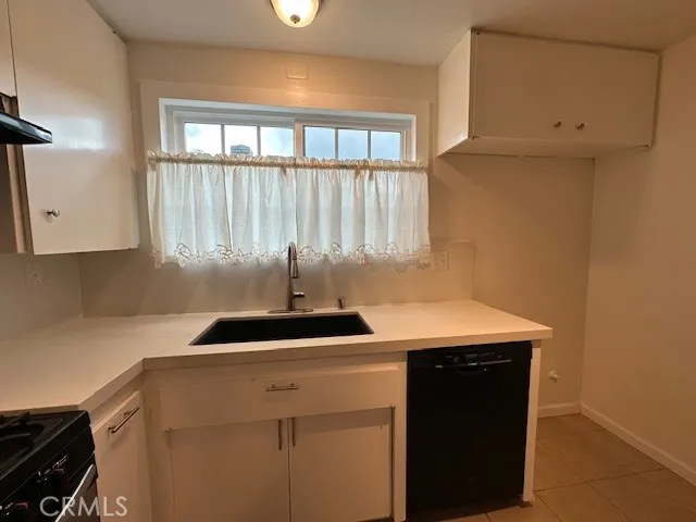 a kitchen with a sink a stove and a window
