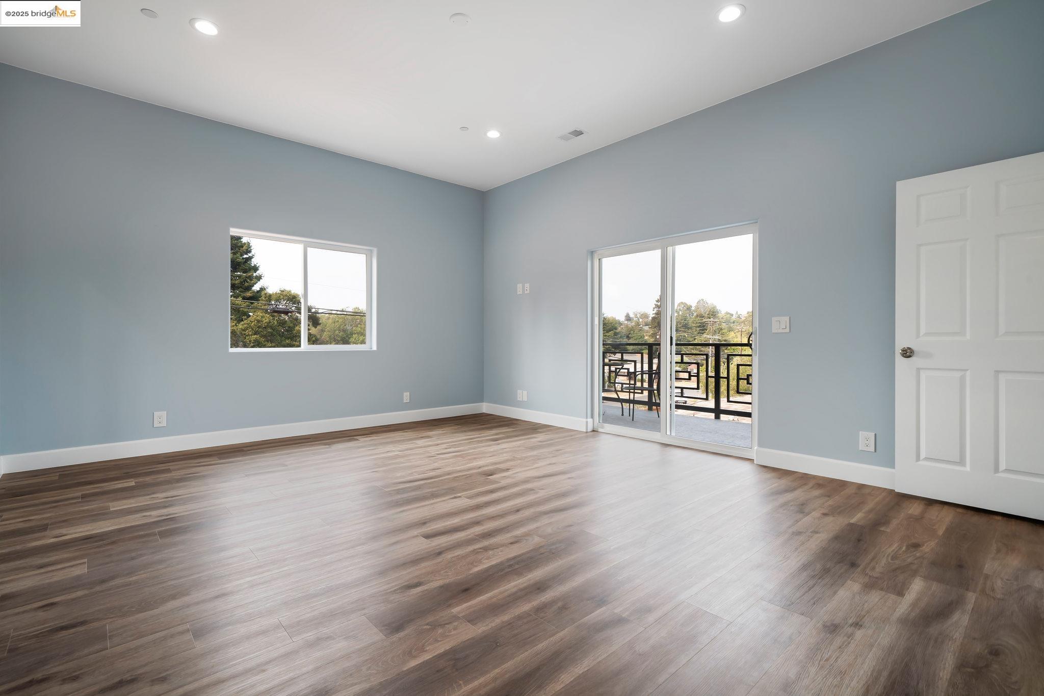 4511 Elmwood Road El Sobrante, CA 94803 - Photo 18 of 42 an empty room with wooden floor and windows