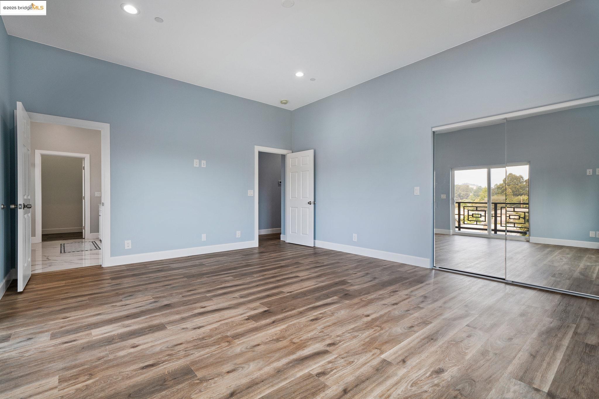 4511 Elmwood Road El Sobrante, CA 94803 - Photo 19 of 42 an empty room with wooden floor and windows