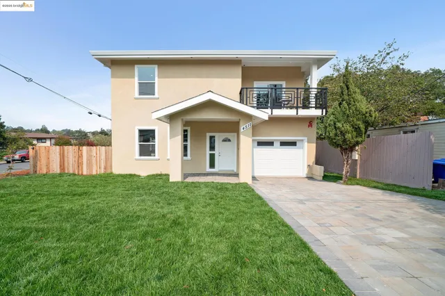 a front view of a house with yard and green space