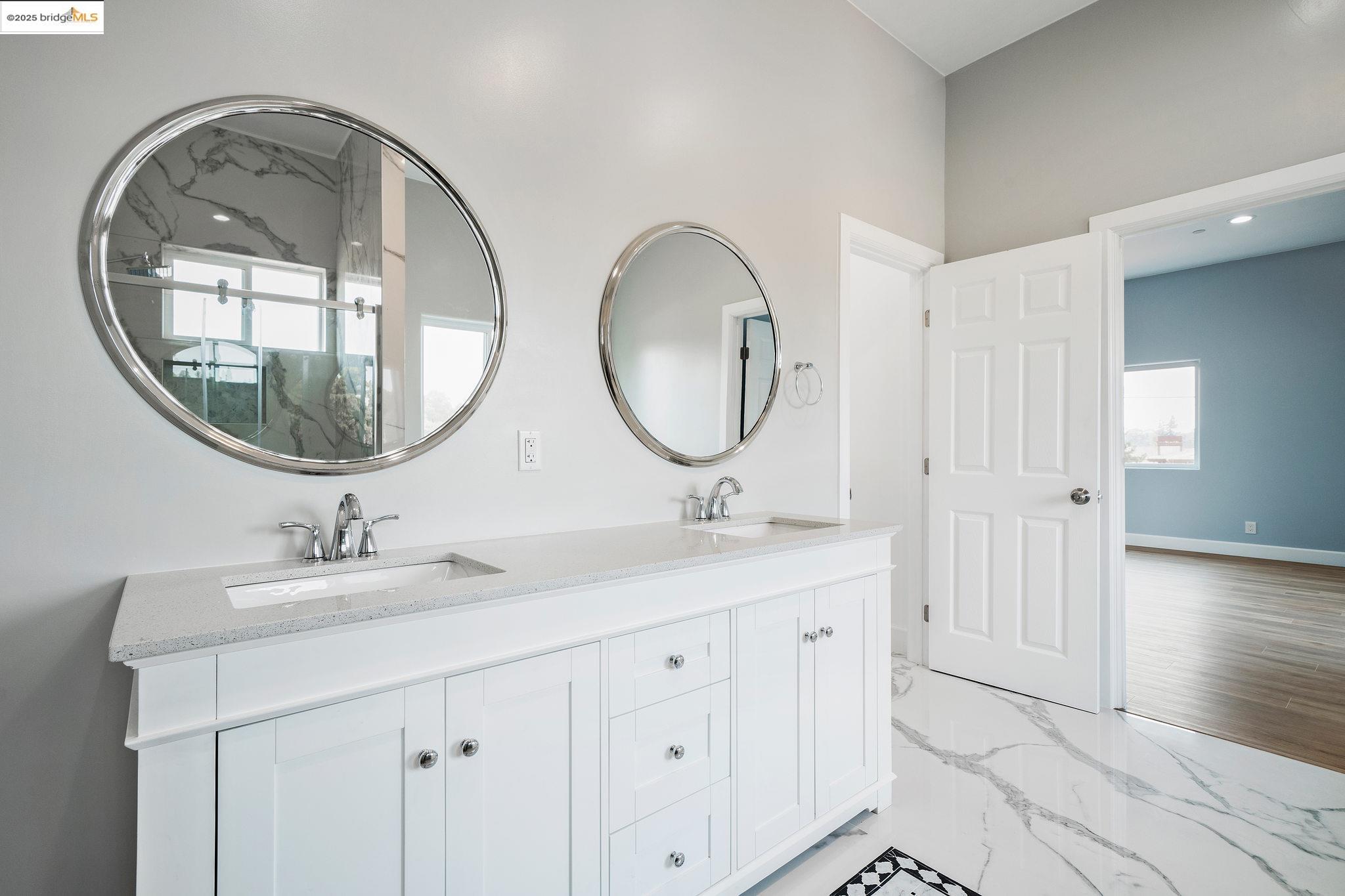 4511 Elmwood Road El Sobrante, CA 94803 - Photo 25 of 42 a bathroom with a double vanity sink and a mirror