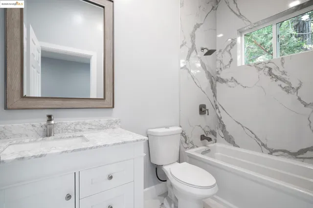 a bathroom with a granite countertop sink a toilet and a mirror