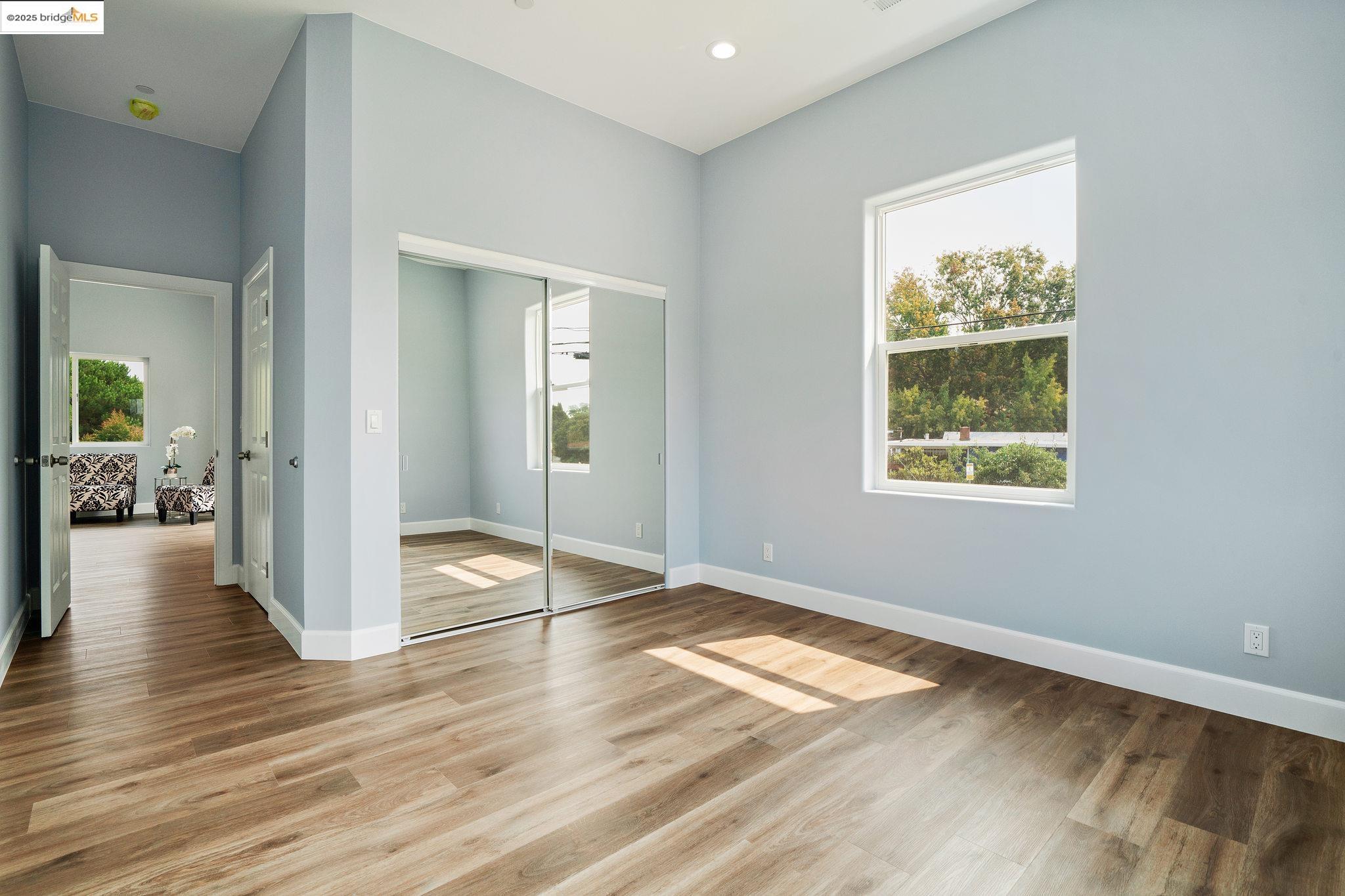 4511 Elmwood Road El Sobrante, CA 94803 - Photo 31 of 42 an empty room with wooden floor and windows