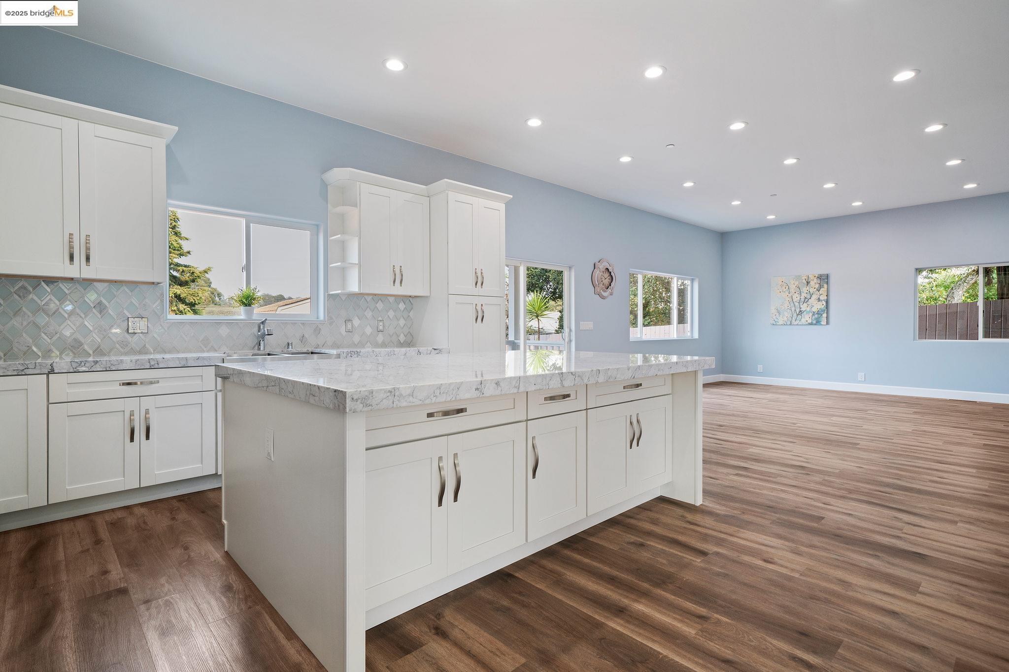 4511 Elmwood Road El Sobrante, CA 94803 - Photo 5 of 42 a kitchen with granite countertop white cabinets and wooden floor