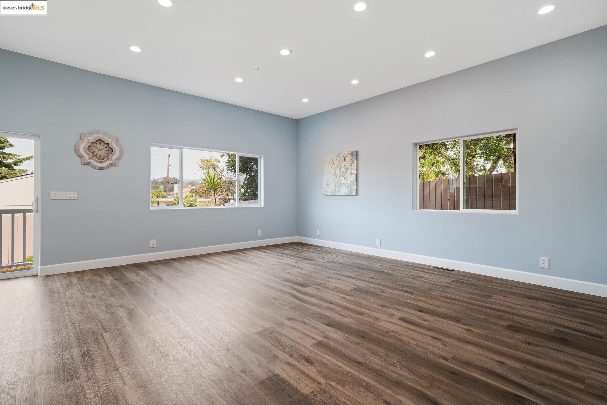 4511 Elmwood Road El Sobrante, CA 94803 - Photo 9 of 42 an empty room with wooden floor and windows
