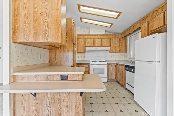 a kitchen with white cabinets and white appliances