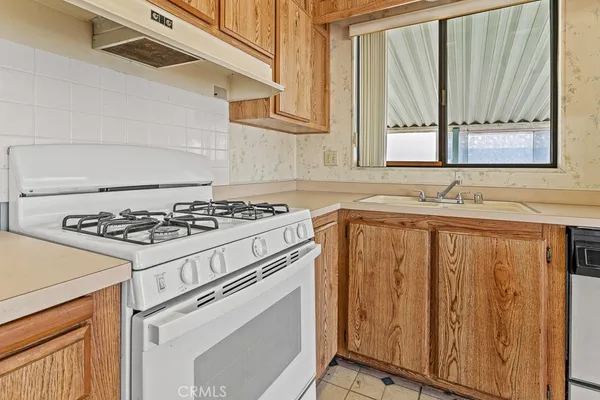 a white stove top oven sitting inside of a kitchen