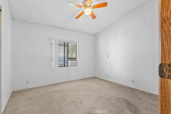 an empty room with windows and a ceiling fan