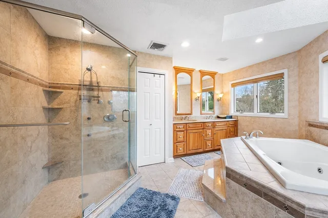 a bathroom with a tub a sink and a large window