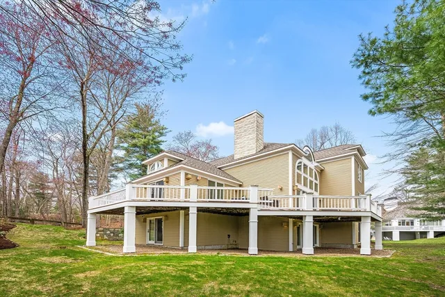 a view of a big house with a big yard and large trees