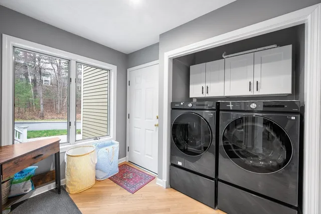 a utility room with wooden floor washer and dryer