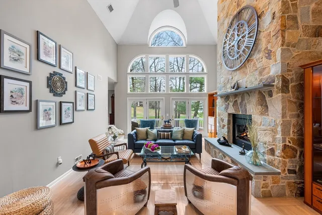 a living room with furniture a fireplace and a clock