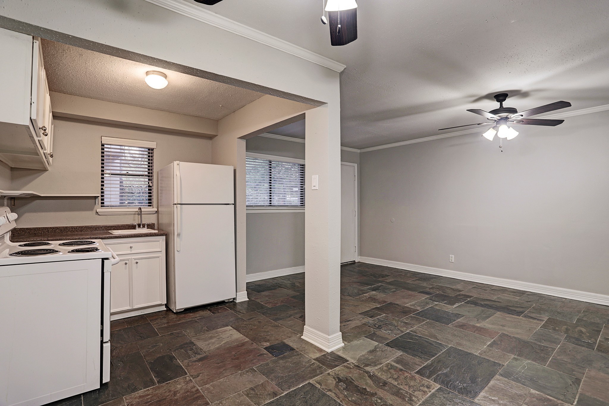 405 Hawthorne Street, Unit 13 Houston, TX 77006 - Photo 3 of 8 a kitchen with refrigerator and white stove top oven