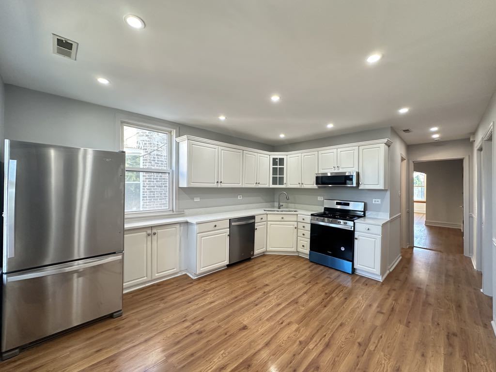 4020 West Cornelia Avenue, Unit 2 Chicago, IL 60641 - Photo 2 of 20 a kitchen with granite countertop a refrigerator and a stove top oven