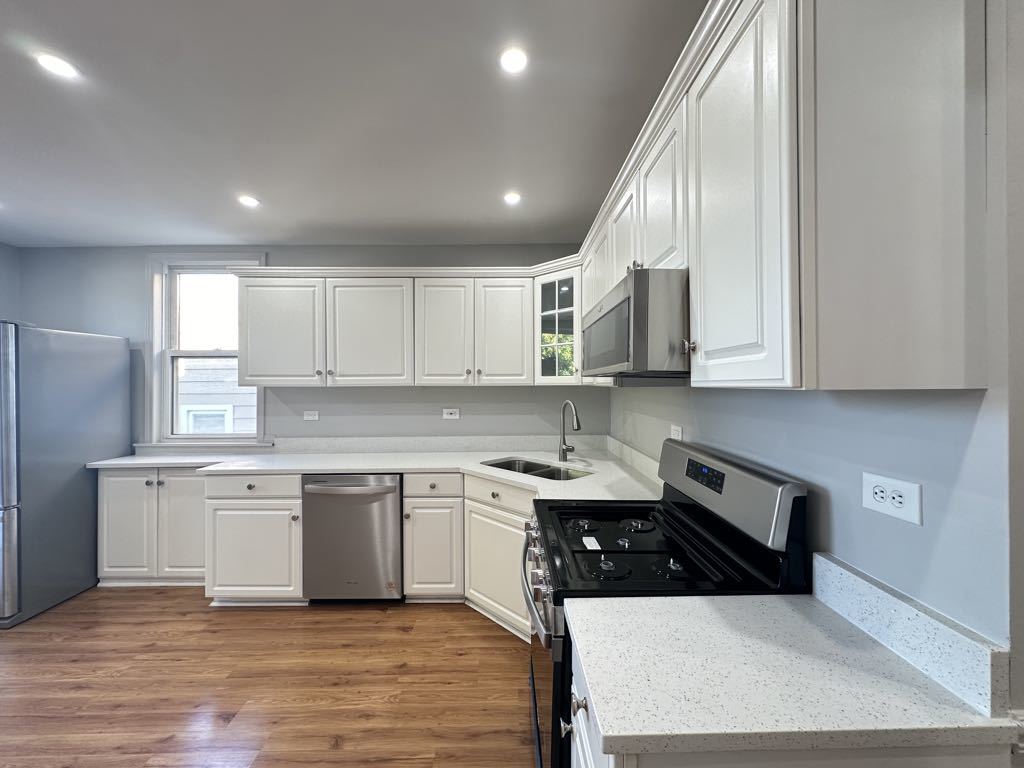 4020 West Cornelia Avenue, Unit 2 Chicago, IL 60641 - Photo 3 of 20 a kitchen with stainless steel appliances a sink a stove a refrigerator and cabinets