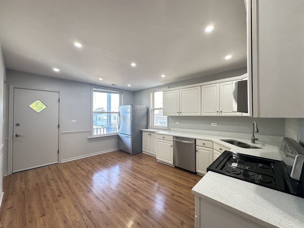4020 West Cornelia Avenue, Unit 2 Chicago, IL 60641 - Photo 4 of 20 a kitchen with a sink window and cabinets