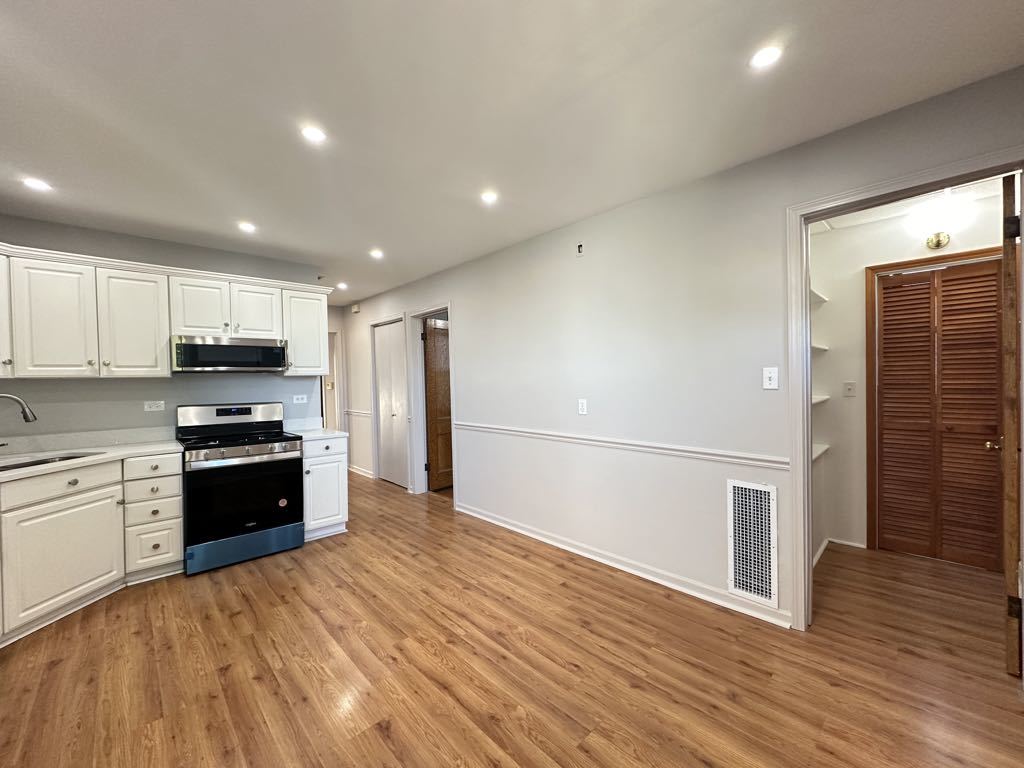 4020 West Cornelia Avenue, Unit 2 Chicago, IL 60641 - Photo 5 of 20 a large kitchen with stainless steel appliances granite countertop a stove and a refrigerator