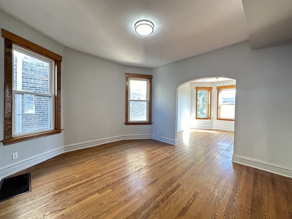 4020 West Cornelia Avenue, Unit 2 Chicago, IL 60641 - Photo 6 of 20 a view of an empty room with wooden floor and a window